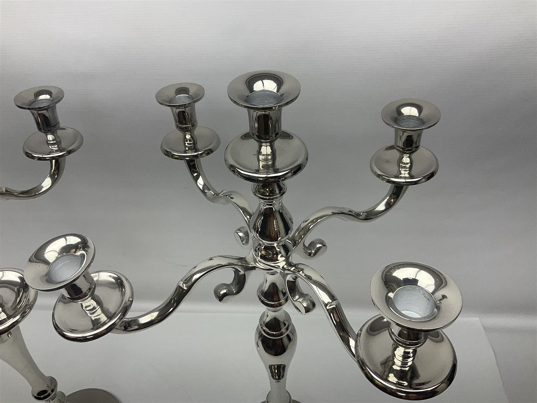 Pair of four branch candelabras, urn-shaped nozzles raised upon scroll branches supported from tapering central stem, with circular base, H70cm