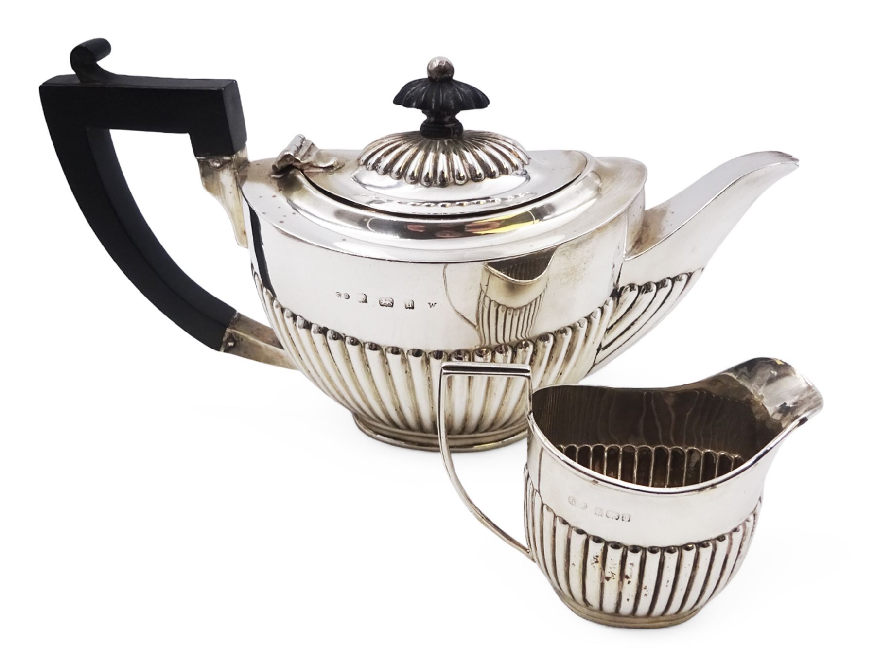 Edwardian silver bachelor's two piece tea set, comprising teapot and milk jug, each of oval part fluted form, the teapot black plastic handle and finial, hallmarked Synyer & Beddoes, Birmingham 1903, teapot H10.5cm