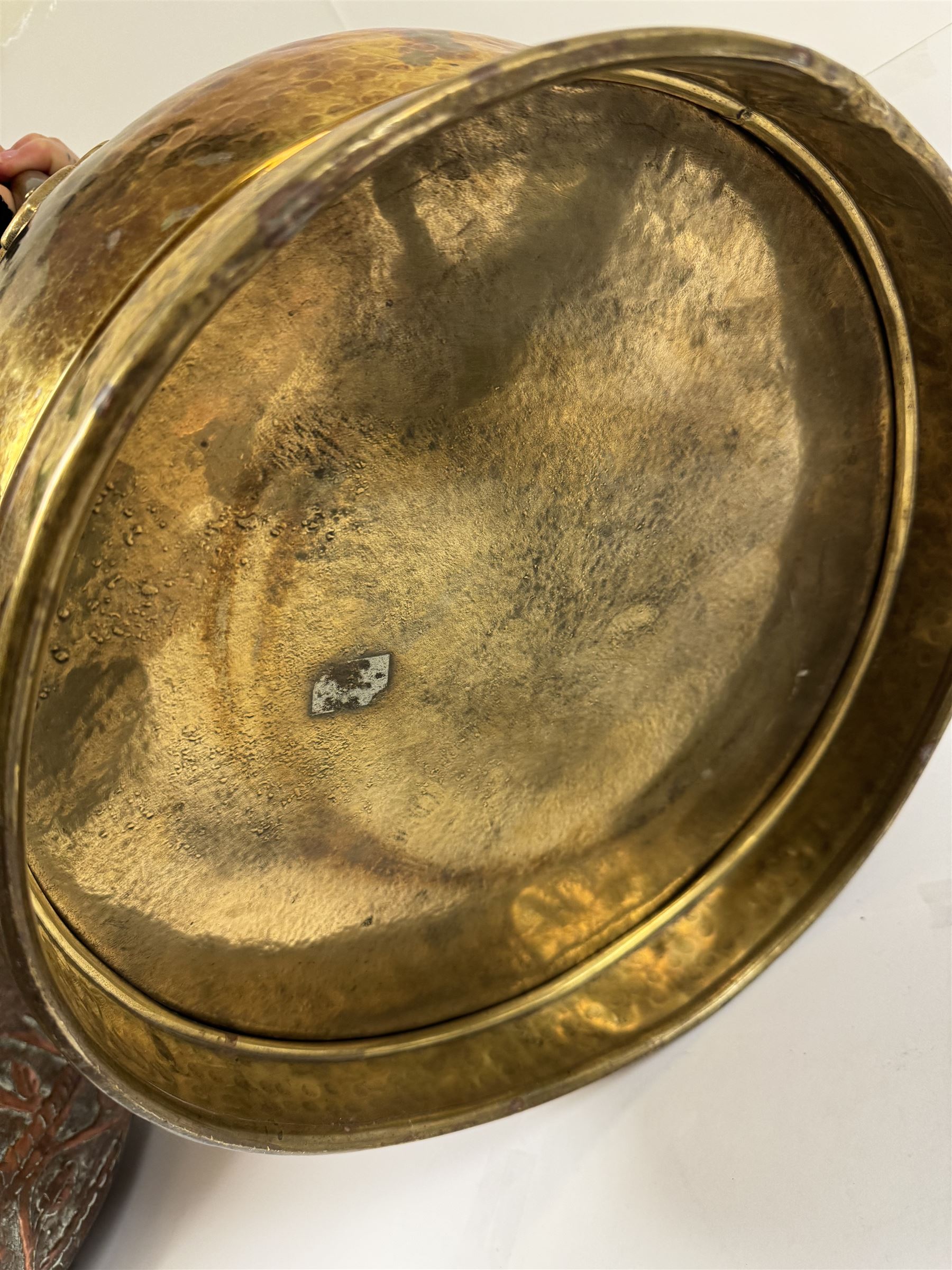 Middle eastern copper bucket, with chased and embossed band of animal decoration, together with a copper jardinière embossed with floral panels, copper plate with embossed leaf motif and two brass helmet shaped coal scuttles, bucket H26cm