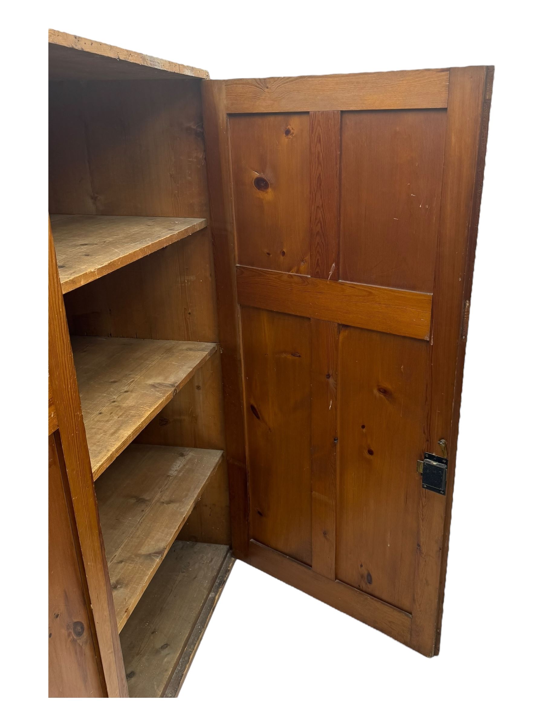 Large 19th century pine cupboard, rectangular top over two panelled later doors, enclosing four open shelves, on plinth base