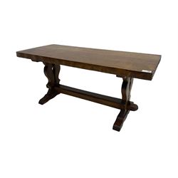 Solid oak coffee table, rectangular waved cut top with tooled ends, on shaped and pierced end supports joined by pegged stretcher 