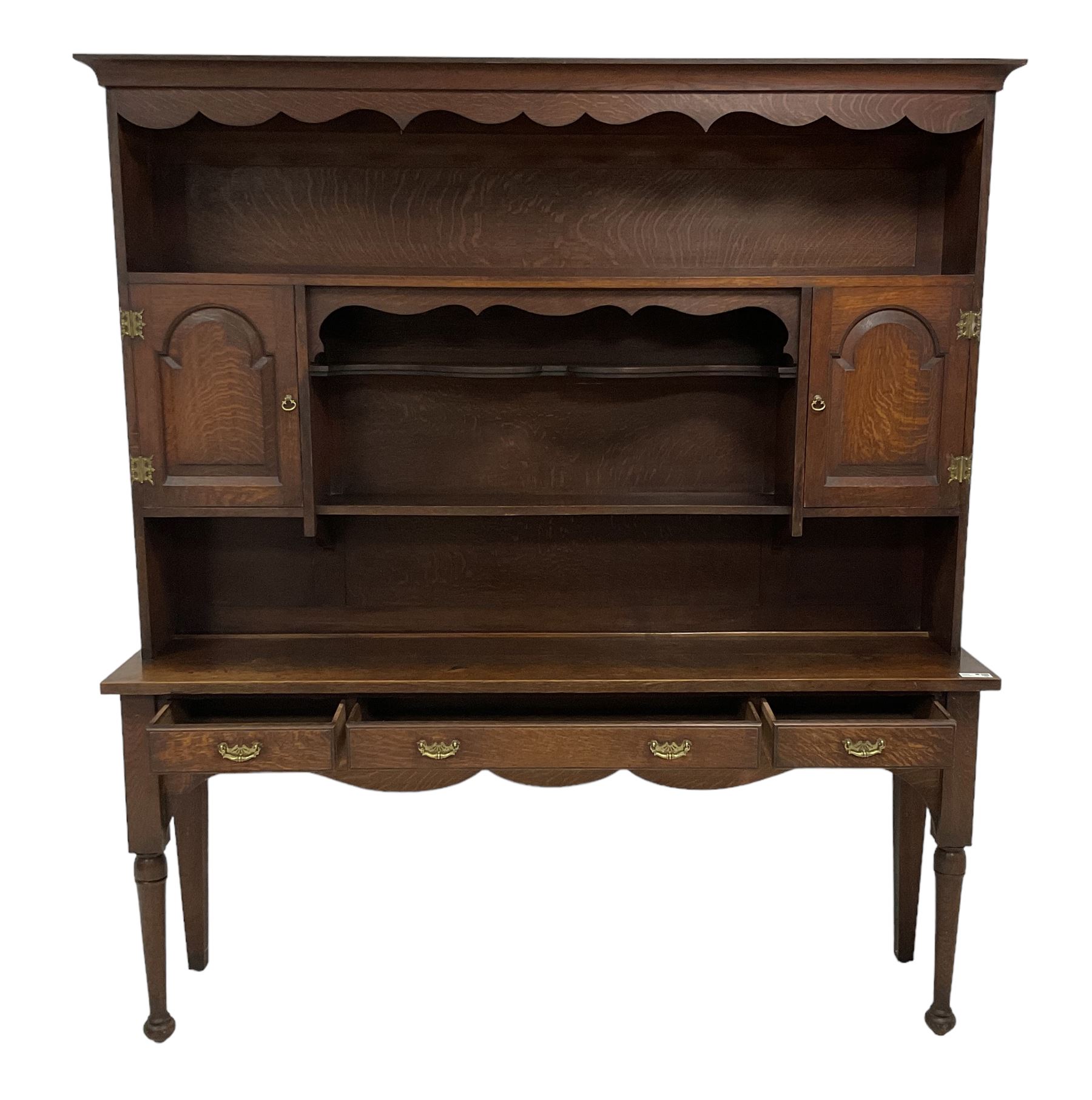 Early 20th century Georgian design oak dresser, projecting cornice with shaped apron over a three-tier plate rack with flanking fielded spice cupboards, the base fitted with three drawers, on turned supports