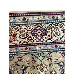 Persian Kashan olive ground carpet, central rosette medallion surrounded by swirling leafy branches and palmettes, the spandrels decorated with further palmettes and foliate motifs, scrolling border interspersed with stylised plant motifs, with in guard stripes