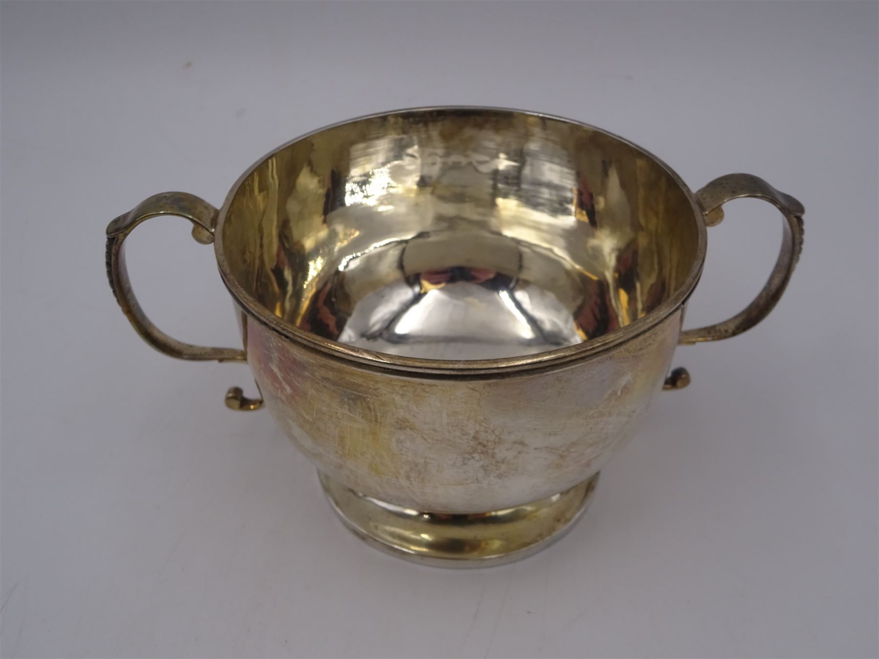 Late Victorian silver twin handled bowl, of plain circular form with two C scroll handles, upon a circular foot, hallmarked John Edward Wilmot, Birmingham 1897, including handles H8cm