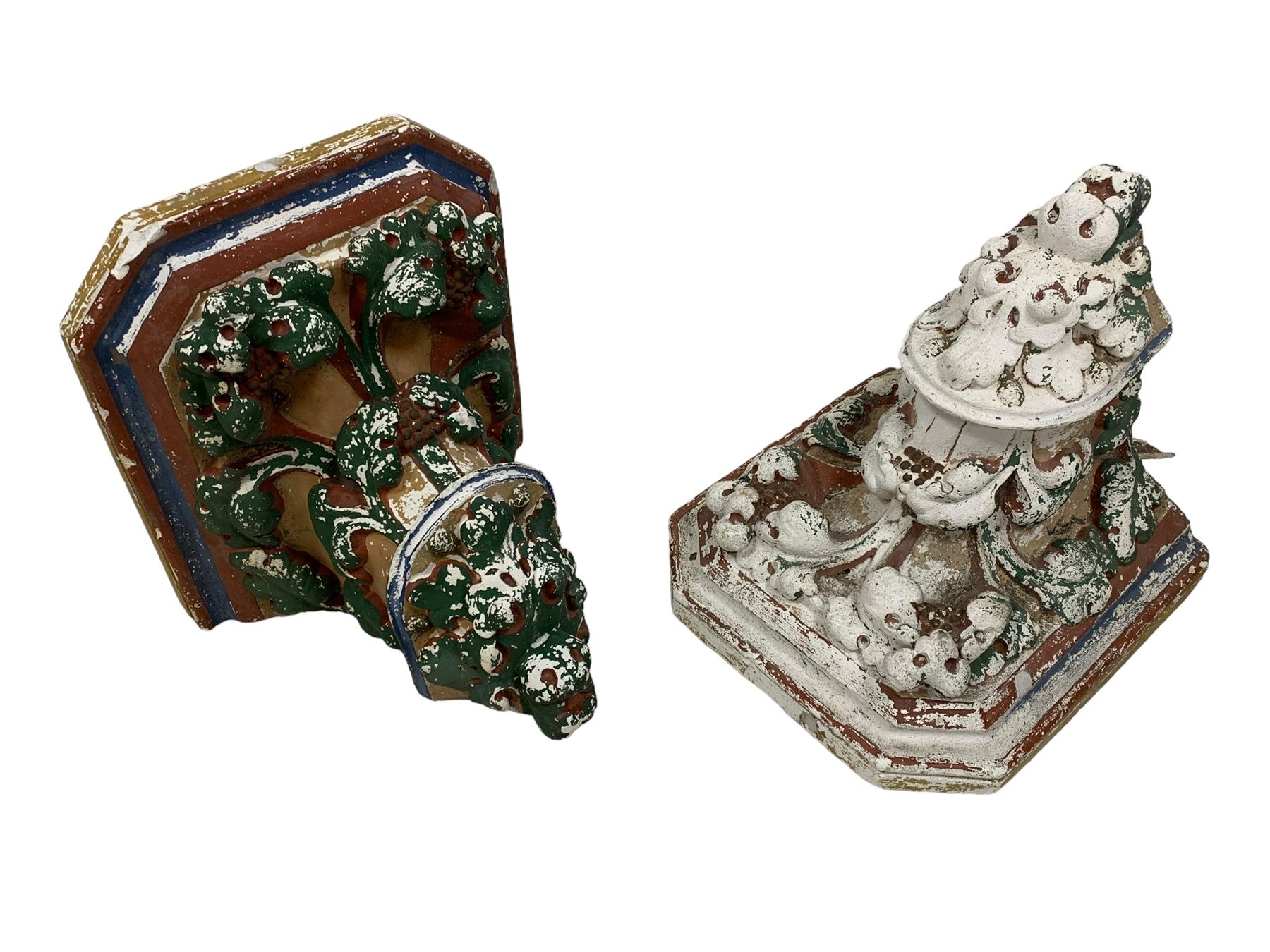 Two Victorian polychromed plaster cast corbels or wall brackets, canted rectangular tops over moulded edge and curled fruiting foliage