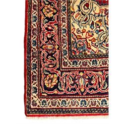 North west Persian Sarouk crimson ground rug, central floral medallion surrounded by scrolling branches decorated with foliage and stylised plant motifs, the main border decorated with repeating scrolling design with floral motifs, within guard stripes 