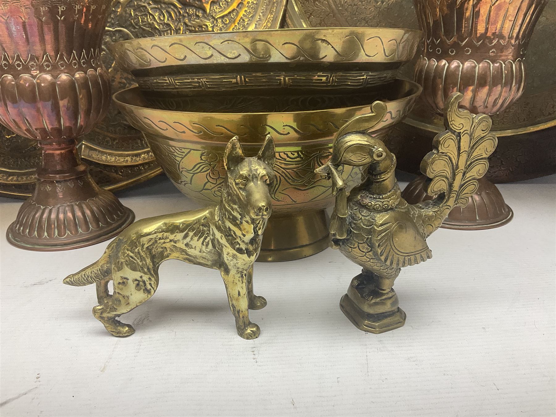 Collection of oriental brass and other metal ware, to include to large chargers, pair of covered urns, hoho bird, etc, largest charger D63cm