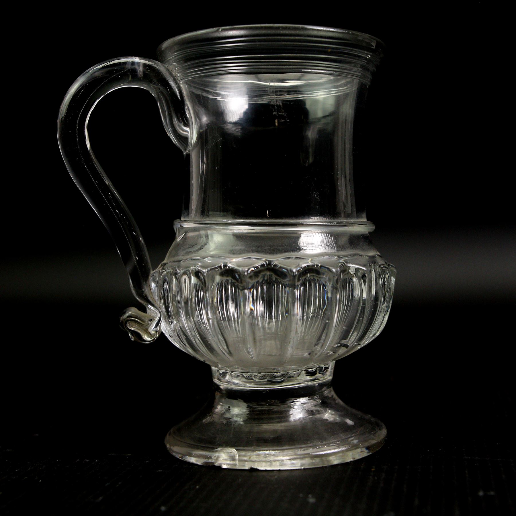 Glass coin jug, with ribbed body and inset with a George II silver 1d penny, H11cm; an 18th century Shrub decanter, circa 1785, H15.5cm; together with an 18th century English green wine bottle, H29.5cm (3)