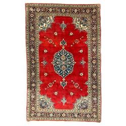 Persian Kashan crimson ground rug, the field decorated with interlacing medallion, floral design spandrels, guarded border with scrolling design decorated with stylised plant motifs