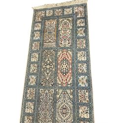 Fine Persian Kashmir ivory and pale indigo ground runner rug, the field decorated with sixteen rectangular panels depicting Mirab motifs and other traditional carpet designs, the border with repeating square panels of floral bouquets and foliate patterns