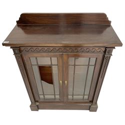 19th century mahogany display cabinet, rectangular top over frieze decorated with Vitruvian scroll mount, enclosed by two astragal glazed doors, the upright rails decorated with trailing bellflowers, on moulded plinth