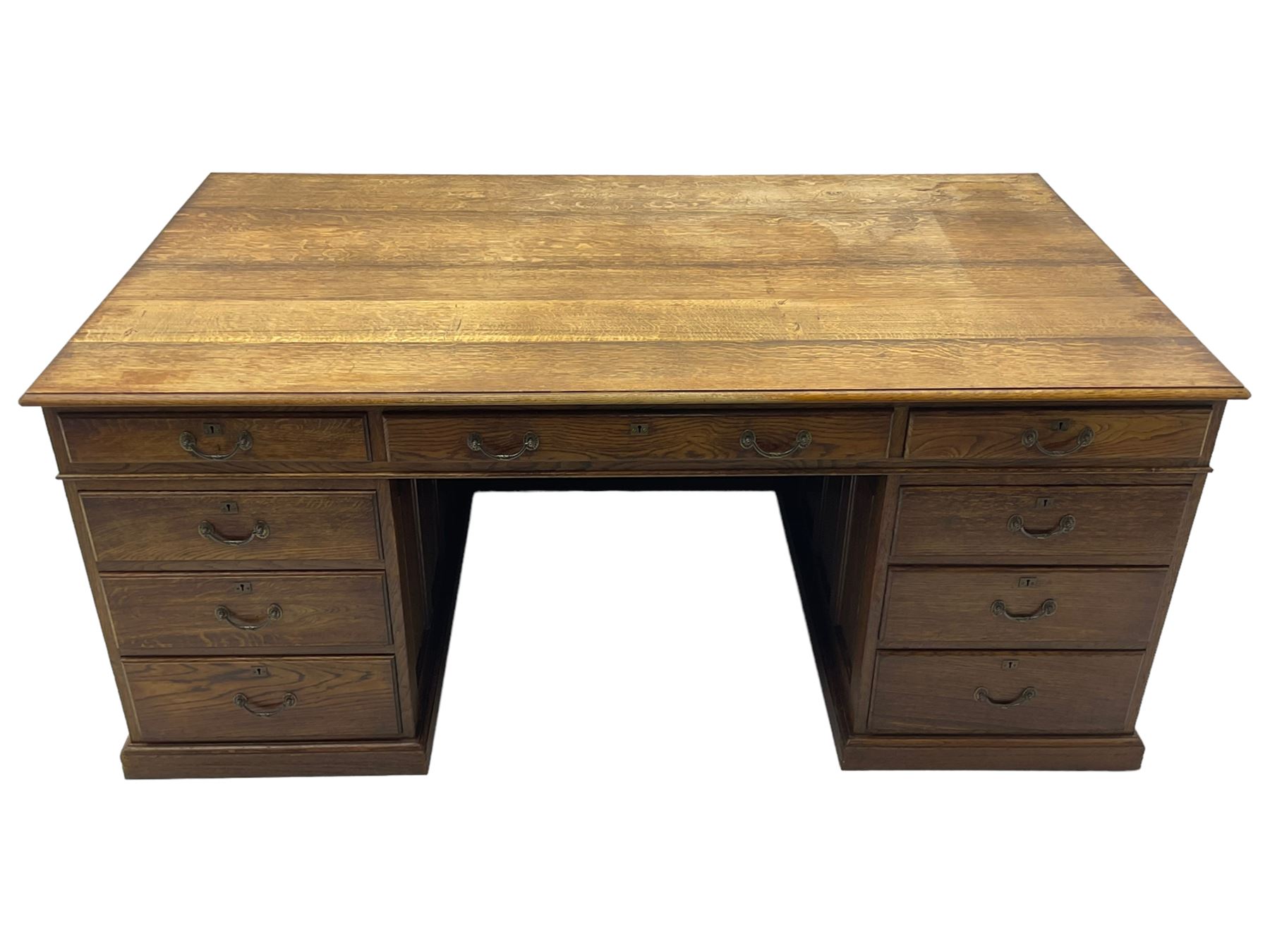 Large 20th century oak twin pedestal desk, moulded rectangular top over nine drawers, panelled pedestals, on moulded plinth base 