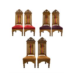 Set of six 20th century Carolean design oak high back chairs, the pediment carved with dragons and central Green Man mask with trailing foliage, the backs upholstered in striped fabric, on turned front supports