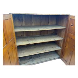 Large 19th century pine cupboard, rectangular top over two panelled later doors, enclosing four open shelves, on plinth base