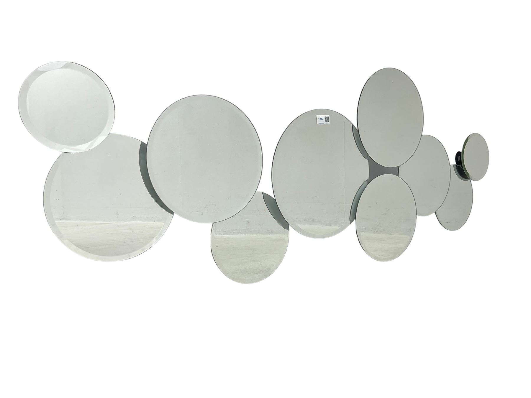 Contemporary abstract circular mirror, comprised of interconnecting bevelled plates of varying sizes