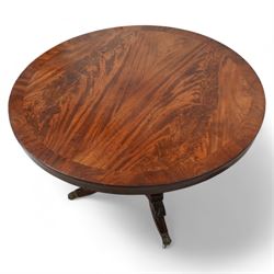 William IV mahogany breakfast or centre table, circular tilt-top with book-matched figured veneers within crossbanding, tapered square column on concaved square platform, four splayed acanthus carved feet with brass hairy paw castors 