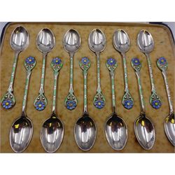 Set of twelve silver coffee spoons, each with enamelled blue flower to terminal and green and white enamel decoration to stem, hallmarked Mappin & Webb Ltd, Birmingham 1934, contained within fitted case