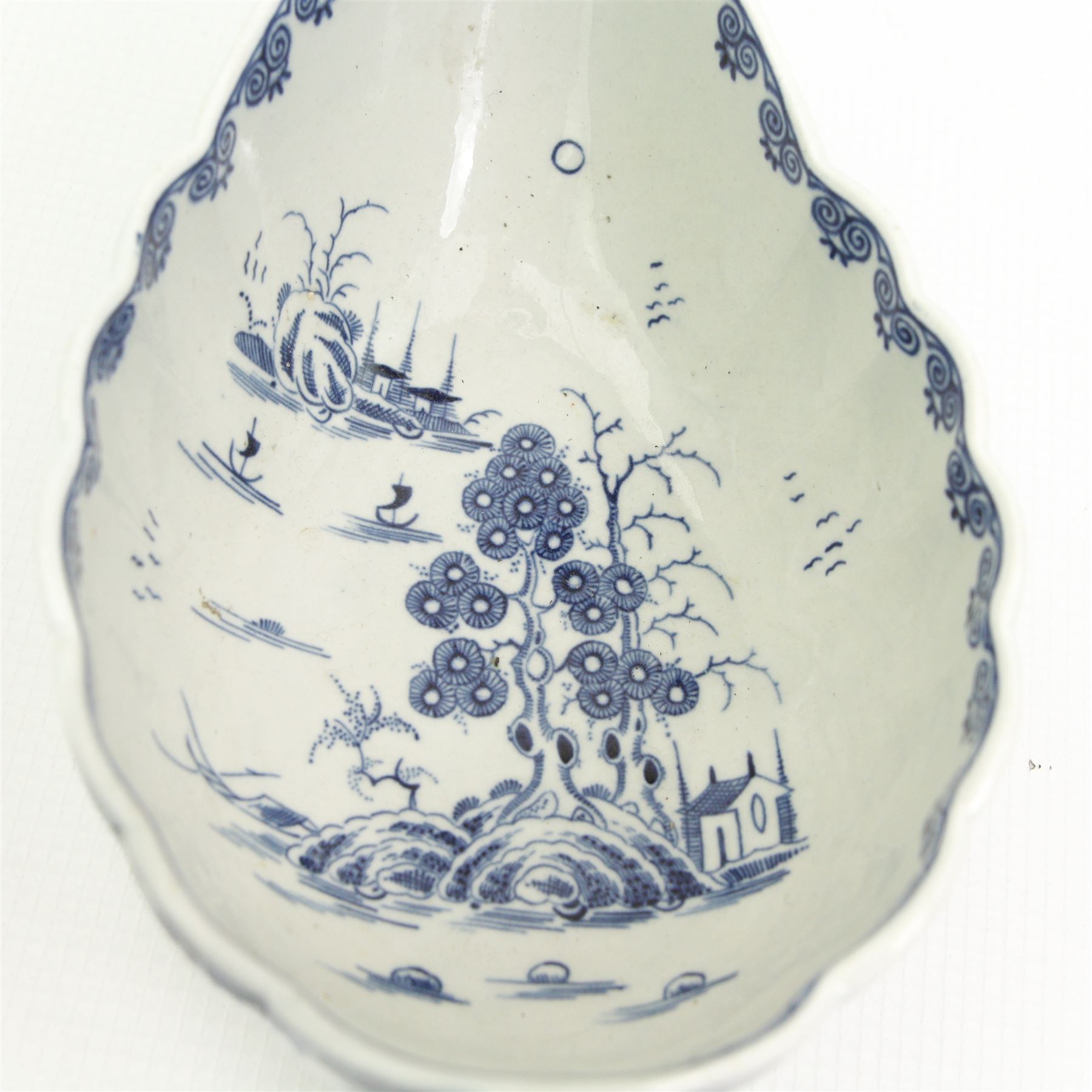 Caughley dessert dish, circa 1785-90, of lobed form and decorated in the Nankin pattern, W23cm together with a Worcester sauceboat, circa 1770-75, painted in underglaze blue with the Doughnut Tree pattern, L22cm 