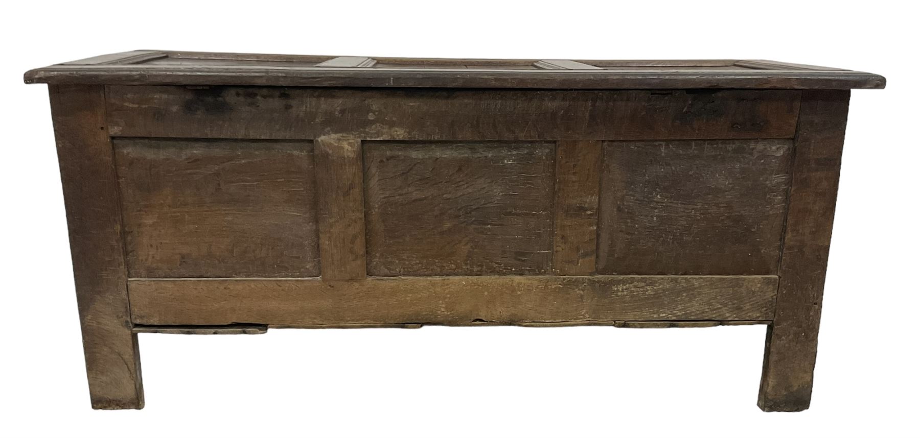 18th century oak coffer or chest, rectangular hinged panelled top with moulded frame enclosing candle box, the frieze carved with foliate S-scrolls over a quadruple panel front decorated with carved lozenges, on stile supports