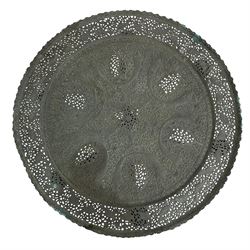 Anglo-Indian Benares table, circular pierced copper top decorated with trailing foliage, on folding hardwood stand carved with scrolls and incised decoration