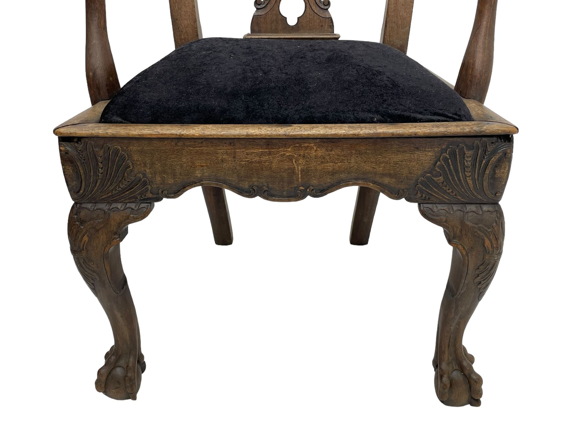 Unusual 18th century mahogany elbow chair, the shaped cresting rail with projecting shell carved ears, pierced and scroll carved splat over drop-in upholstered seat, shaped arms with ball and claw carved terminals, the seat rails carved with shell cartouches, on foliate carved cabriole supports with ball and claw feet 