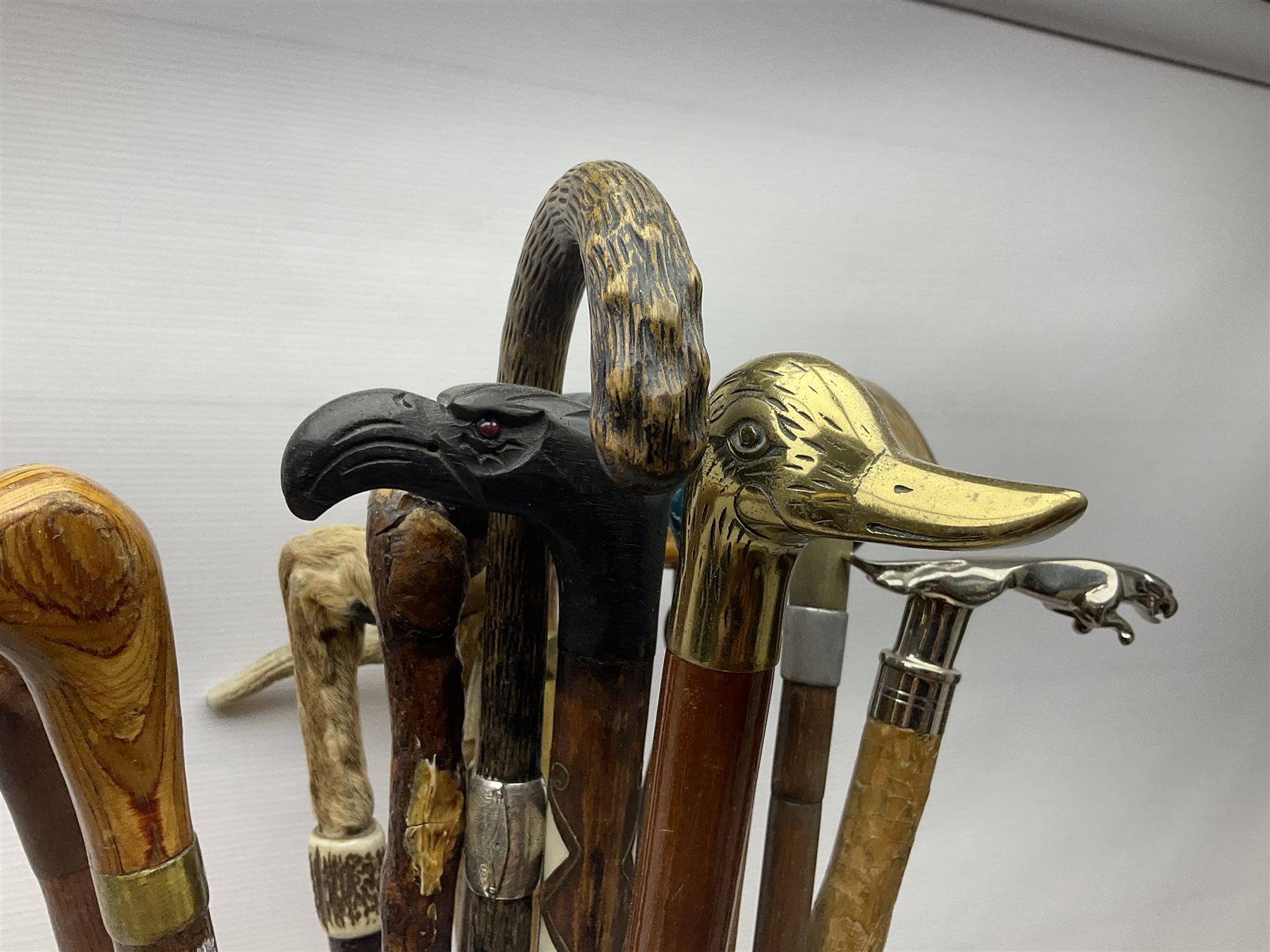 Oak barley twist stick stand, with a collection of walking sticks including examples with carved pommels, horn handles, silver collar etc, together with brass stick stand 