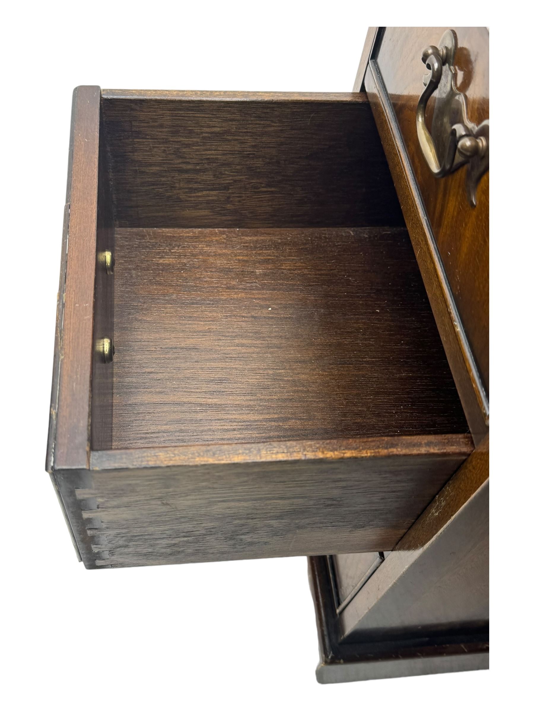 20th century mahogany twin pedestal desk, moulded rectangular top with red leather inset with gilt tooled border, central drawer over kneehole flanked by two banks of four graduating cockbeaded drawers, on plinth base