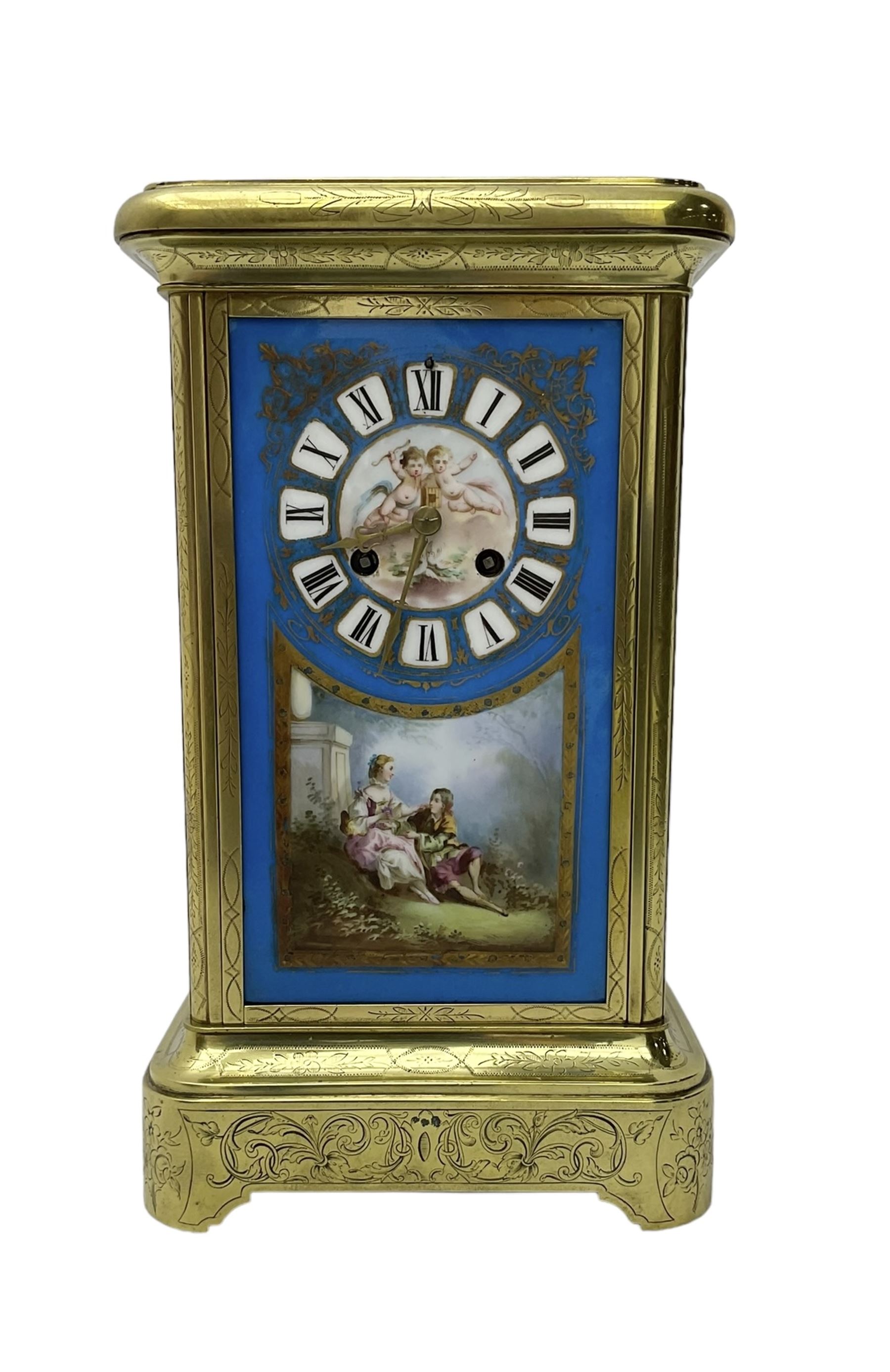 French - late 19th century 8-day mantle clock in an engraved brass corniche case with three rectangular porcelain panels decorated in the romantic Sevres style, dial with brass hands, cartouche Roman numerals and a depiction of cupid to the dial centre, rack striking movement sounding the hours and half hours on a bell. With pendulum.