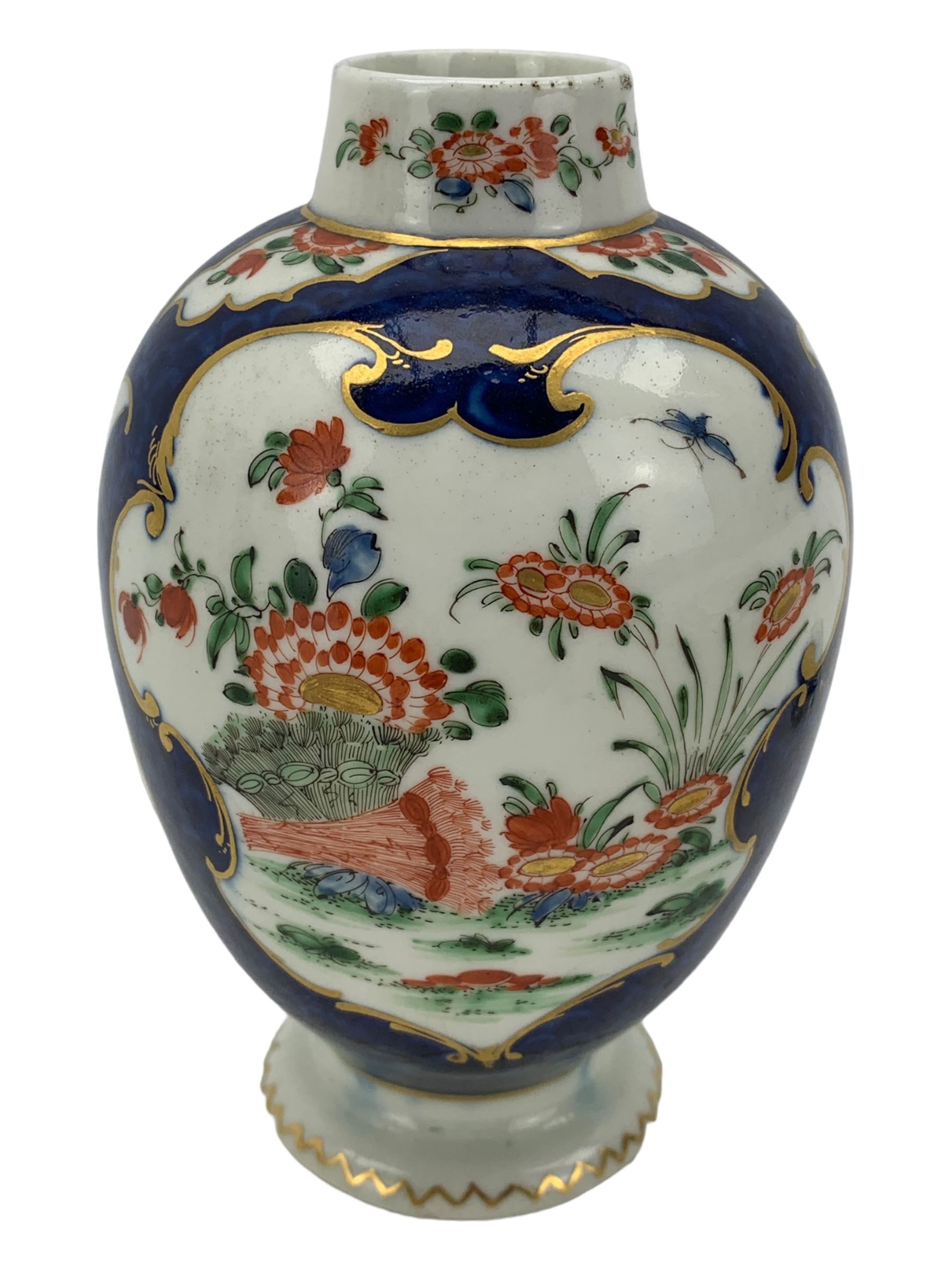 18th century Worcester tea caddy, of oval form and painted in the Kakiemon palette with reserves of flowers against a blue scale ground, H14cm together with a similar Worcester circular dish, painted with floral sprays, within a scalloped edge, blue crescent mark beneath, D19cm (2)