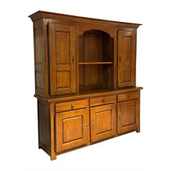 Large 20th century oak dresser, projecting cornice over open arched central section with two shelves, flanked by two panelled cupboards with two shelves, lower section with three drawers above three cupboards, on stile supports 