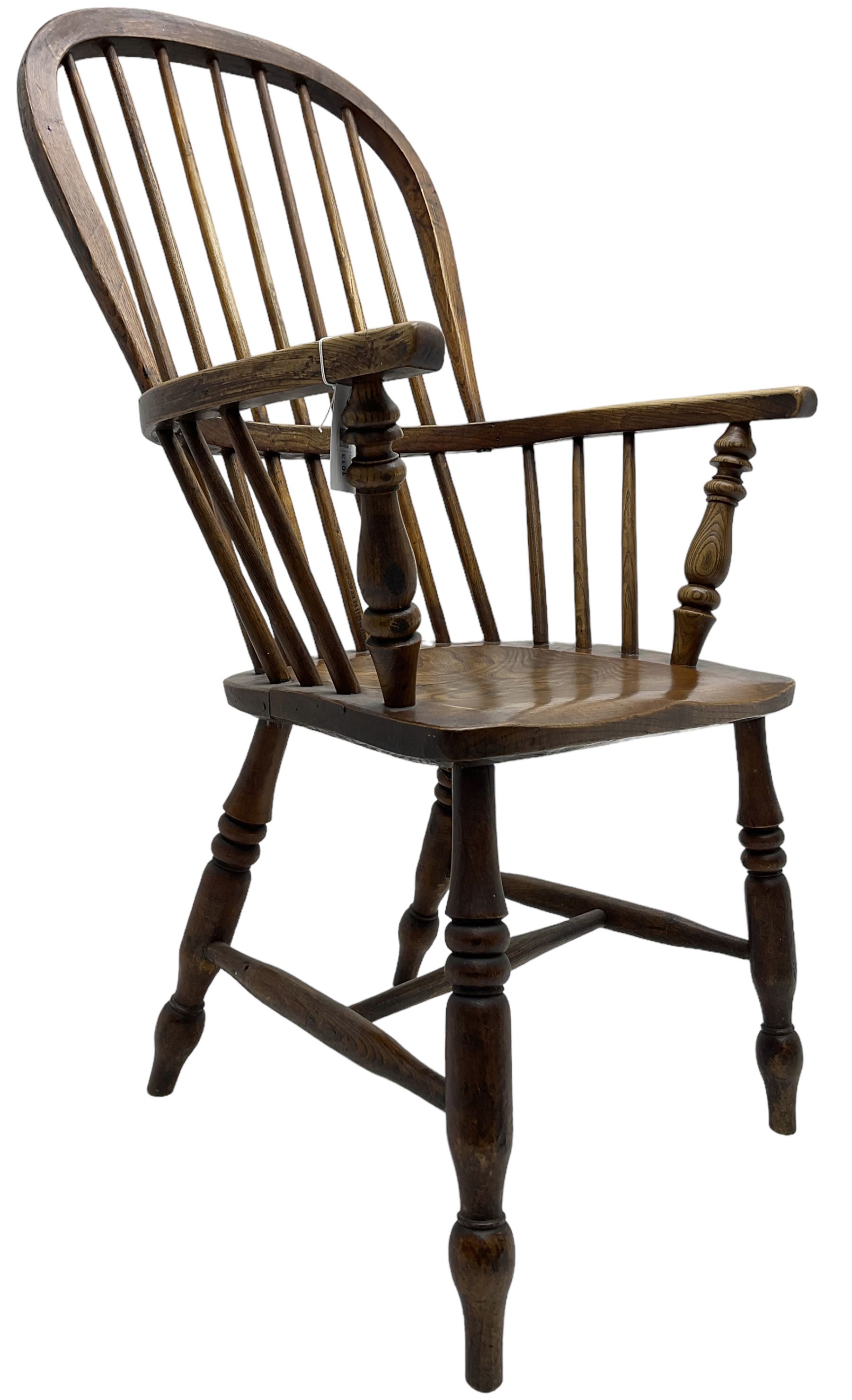 Early 19th century elm Windsor chair, high hoop and stick back over shaped saddle seat, raised on ring turned supports united by H-stretcher