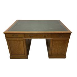 Late 19th century twin pedestal oak partner's desk, rectangular top with inset green leather writing surface, fitted with nine graduating drawers to each side, the rear drawers enclosed by panelled cupboards