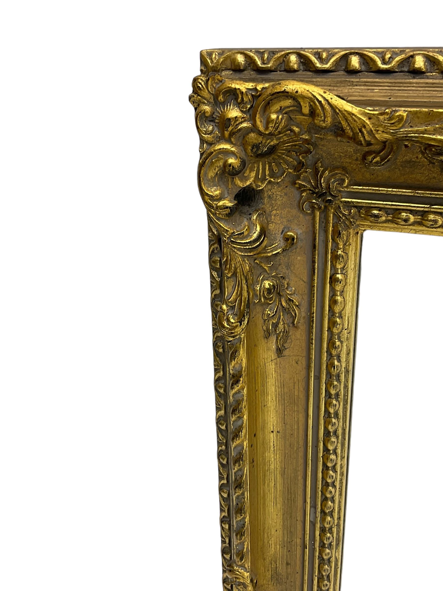 Regency revival style gilt framed oval mirror, the frame with laurel swags topped with urn and flame finial, beaded chain and ram's head motifs, bevelled glass pane; three additional gilt framed mirrors to include one oval and two rectangular (4)