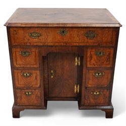 George II figured walnut knee-hole desk, the rectangular quarter-matched veneer top with moulded edge, crossbanding and feathered-banding, fitted with single frieze drawer over three drawers to each side, each with the central recess fitted with a single cupboard enclosing shelf, lower moulded edge on bracket feet