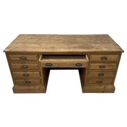 20th century waxed pine kneehole desk, rectangular top over nine drawers with cup handles, on moulded plinth base