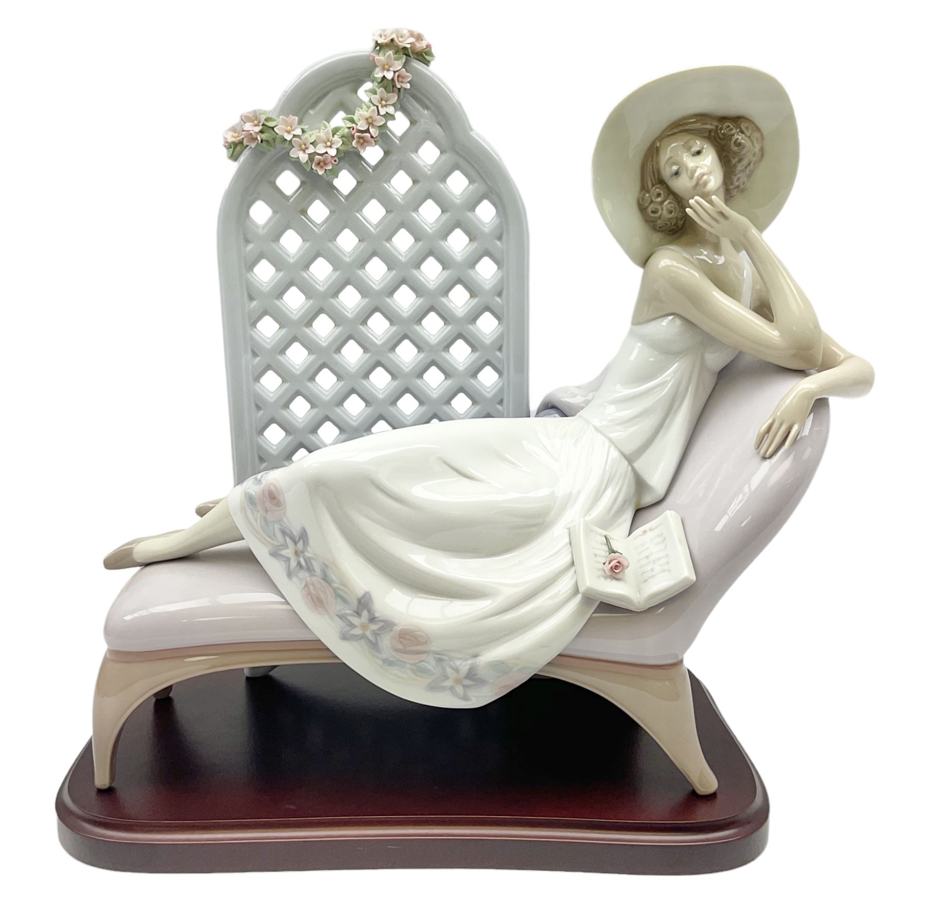 Lladro figure, Garden of Dreams, modelled as a woman reclining in front of trellis of flowers on a mahogany base, limited edition 3561/4000, with original box, no 7634, year issued 1994, year retired 1996, H32cm  