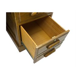 Early 20th century oak tambour roll-top desk, the top with fitted interior including drawers, pigeonholes and compartments, the twin pedestals fitted with four drawers with carved handles, supported by plinth base 