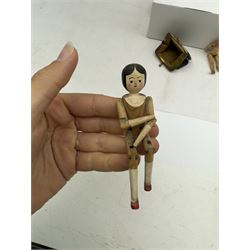 Four miniature dolls with articulated limbs, and a miniature purse