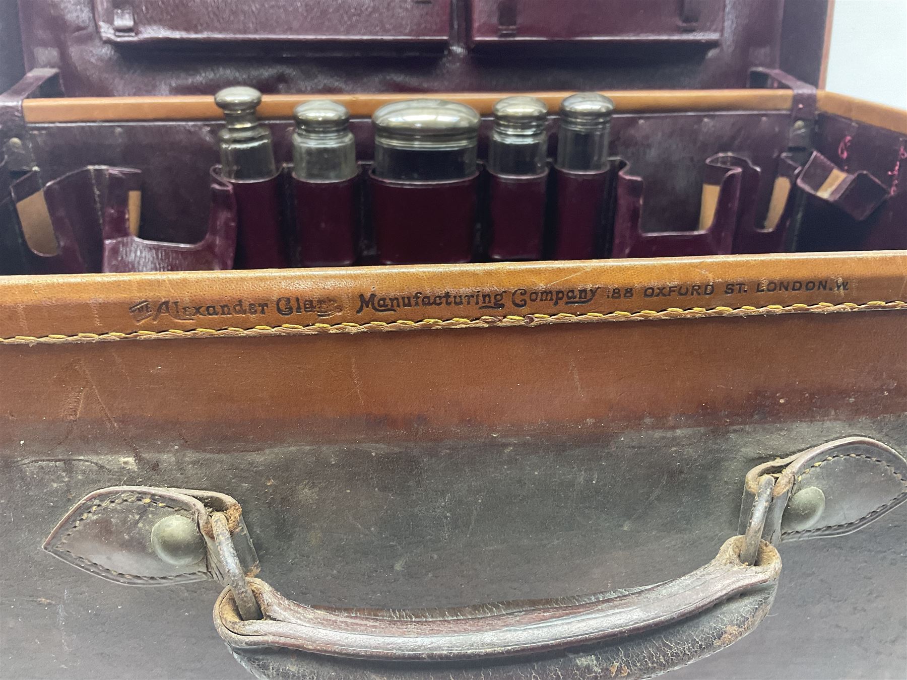 Early 20th century leather bound travelling case, with initials to cover, with fitted interior containing five silver topped glass jars, each engraved with initials, hallmarked The Alexander Clark Manufacturing Co, London 1910 & 1911, case W61cm