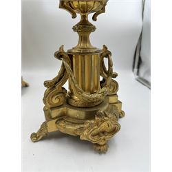 Pair of French Louis XV style gilt metal candelabra, each with four foliate scroll arms supporting fluted urn sockets above foliate edged drop pans, and surrounding a central conforming socket with foliate snuffers, upon ornately modelled stems with urn knops leading to fluted pedestals hung with husk swags, upon stepped bases with scroll feet, overall H53cm
