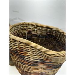 Two rattan baskets, of circular abstract form, together with two crook walking stick, basket H62cm 