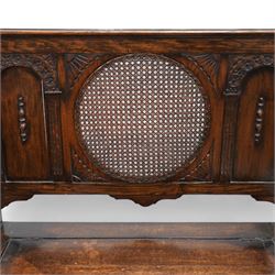 Early 20th century oak hall bench, circular caned back enclosed by panels decorated with flowerhead carved arcades, hinged box seat, panelled front 