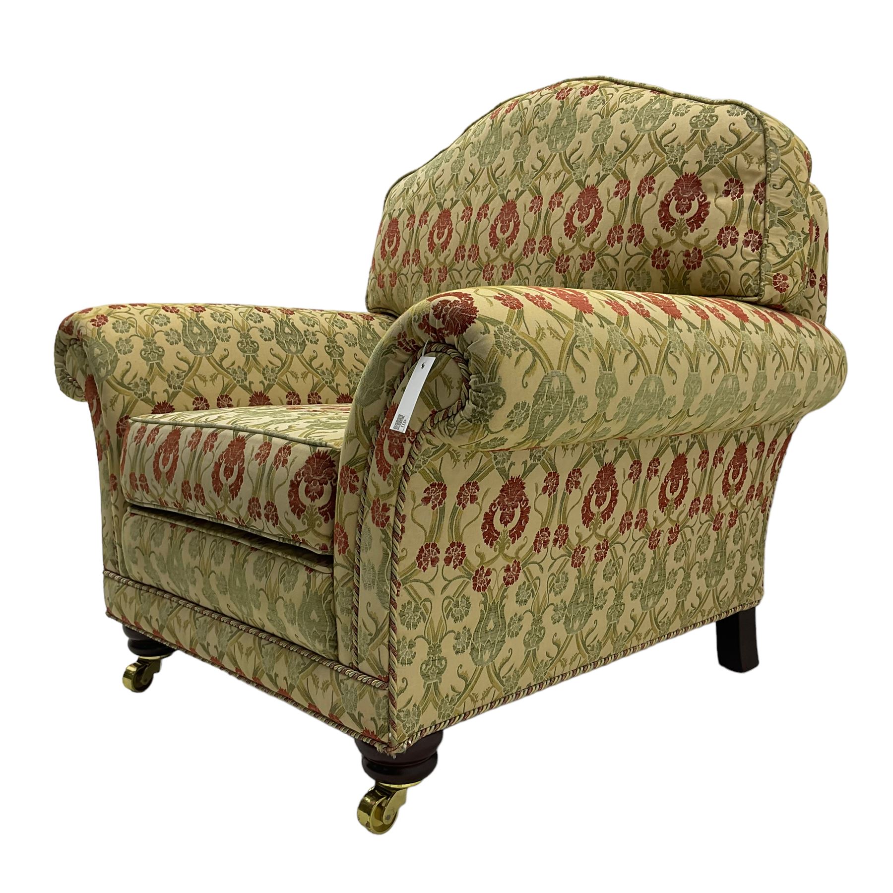 Traditional design two seat sofa, high back with scrolled arms, upholstered in beige fabric with red and green damask motifs, on castor supports (L178cm, D100cm, H89cm); matching armchair (L109cm, D89cm, H89cm)