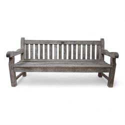 'J.V.T. Ampleforth' - teak garden bench, plain cresting rail with applied maker's plaque over slatted back and seat, on square supports 