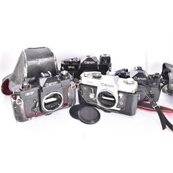 Four Canon SLR camera bodies, to include F-1 serial no. 273243, A-1 serial no. 1818620, EF serial no. 317419, all in black finish, with Canon cases, and an FT serial no. 251226 in black and silver finish