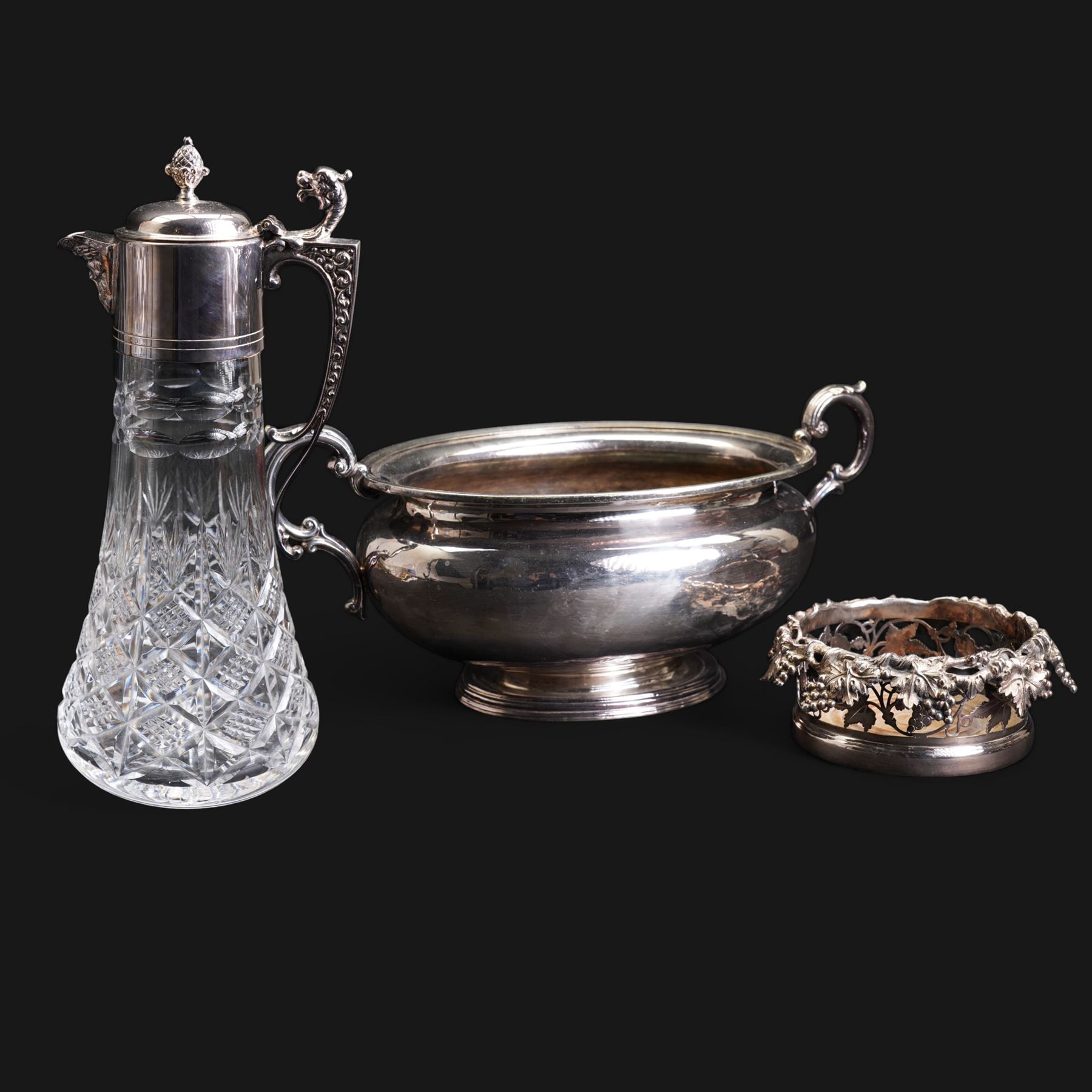 20th century silver-plated bottle coaster with grape vine decoration, cut glass claret jug with silver-plated mounts, H30cm and an early 20th century Elkington silver plate soup tureen, lacking cover 