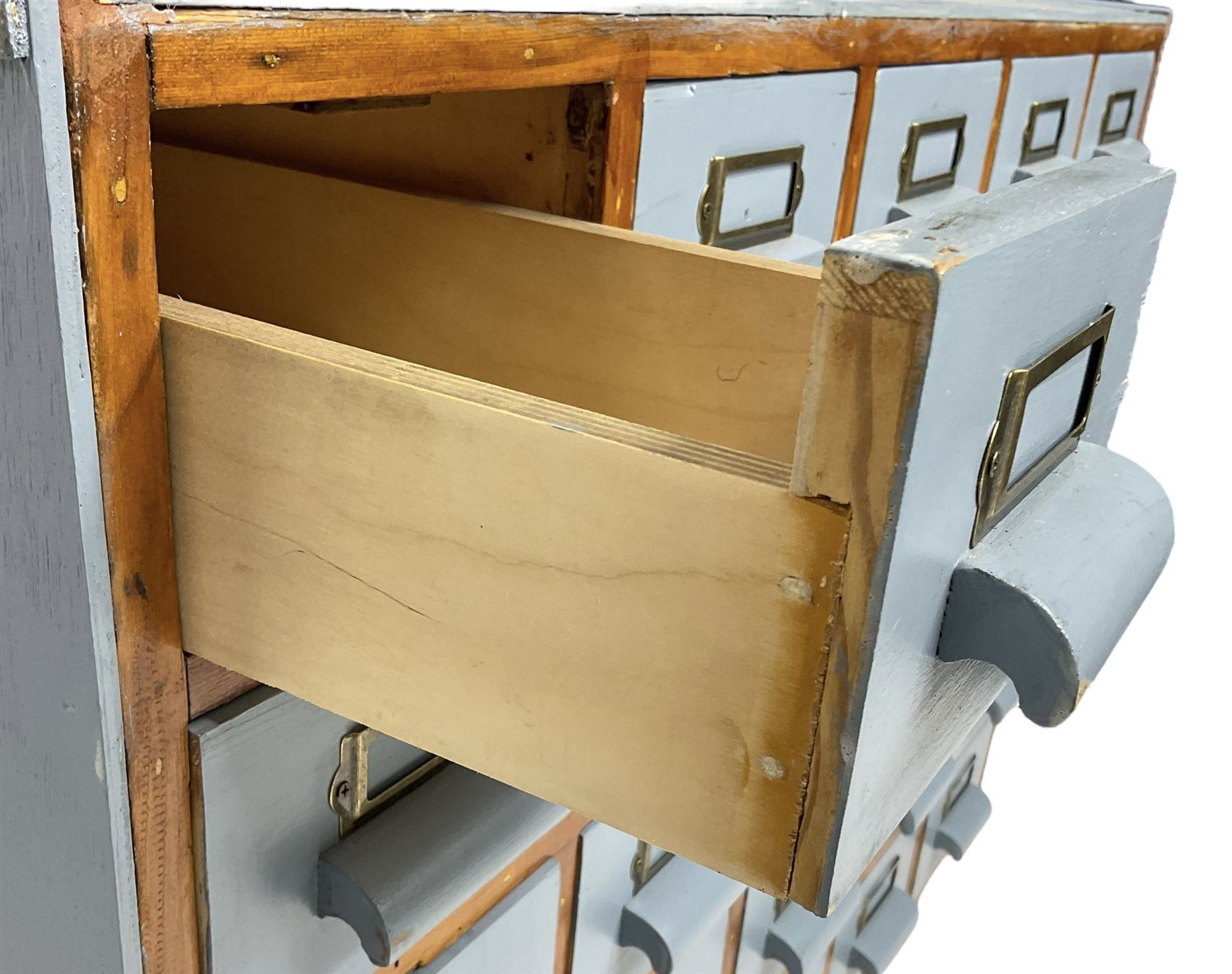 Mid-20th century multi-drawer chest or filing cabinet, fitted with twenty-five small drawers with wooden handles and metal label holders, in light blue paint finish 