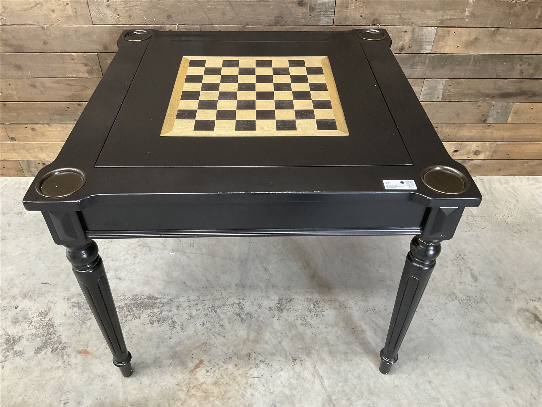 Ebonised square games table, reversible chessboard top revealing games compartment