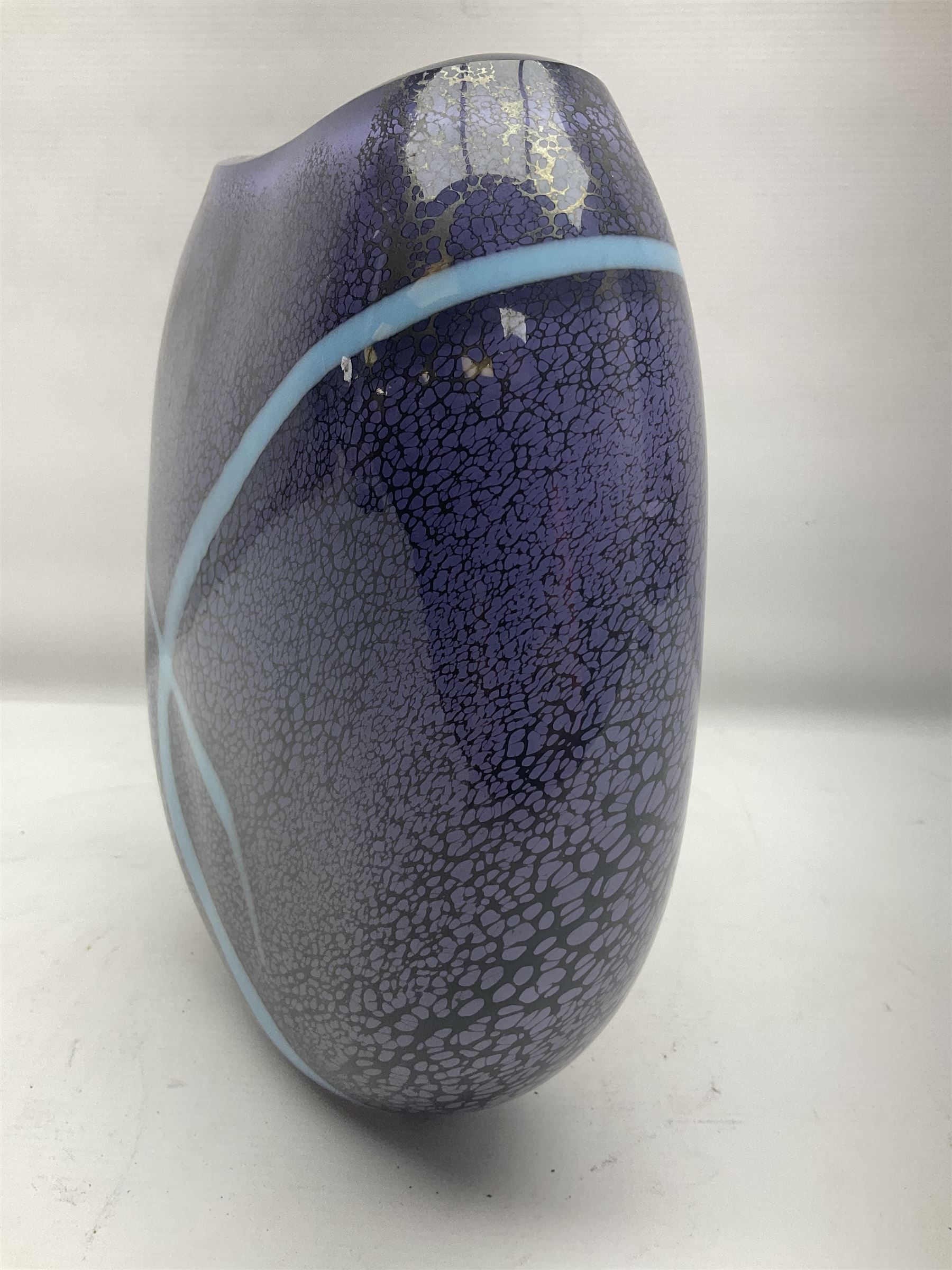 Stuart Akroyd glass vase, with blue ribbon decoration upon a mottled purple ground, engraved signature and sticker beneath, H25.5cm