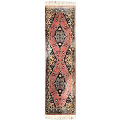 Northwest Persian salmon ground runner, the field decorated with a series of geometric medallions, surrounded by a multi-band border with floral motifs